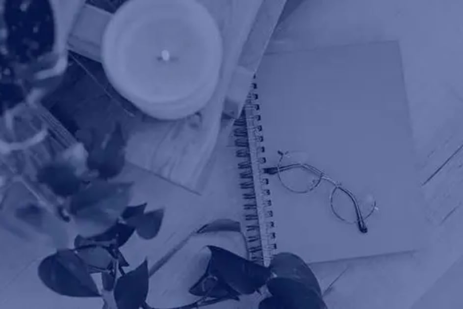 Image of table with a candle, greenery and journal