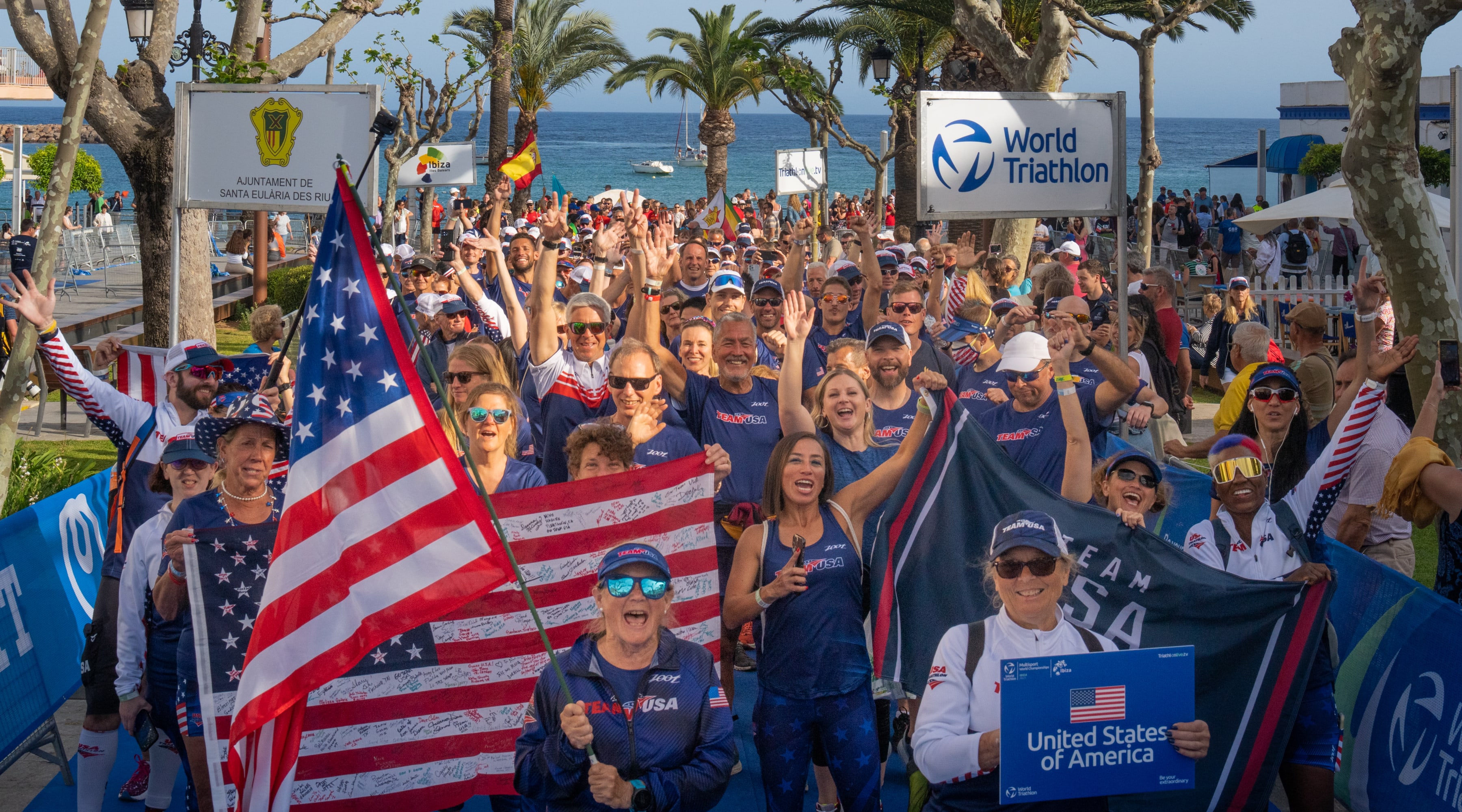 U.S. age group athletes wearing red, white and blue walk in a parade
