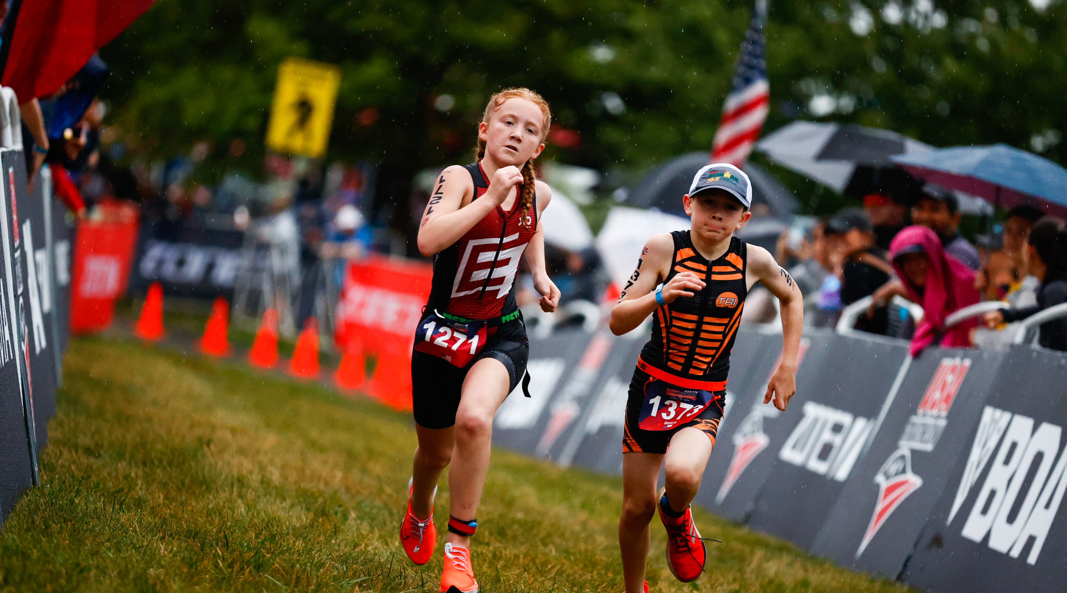 Two youth athletes sprint side by side down the finishing chute.