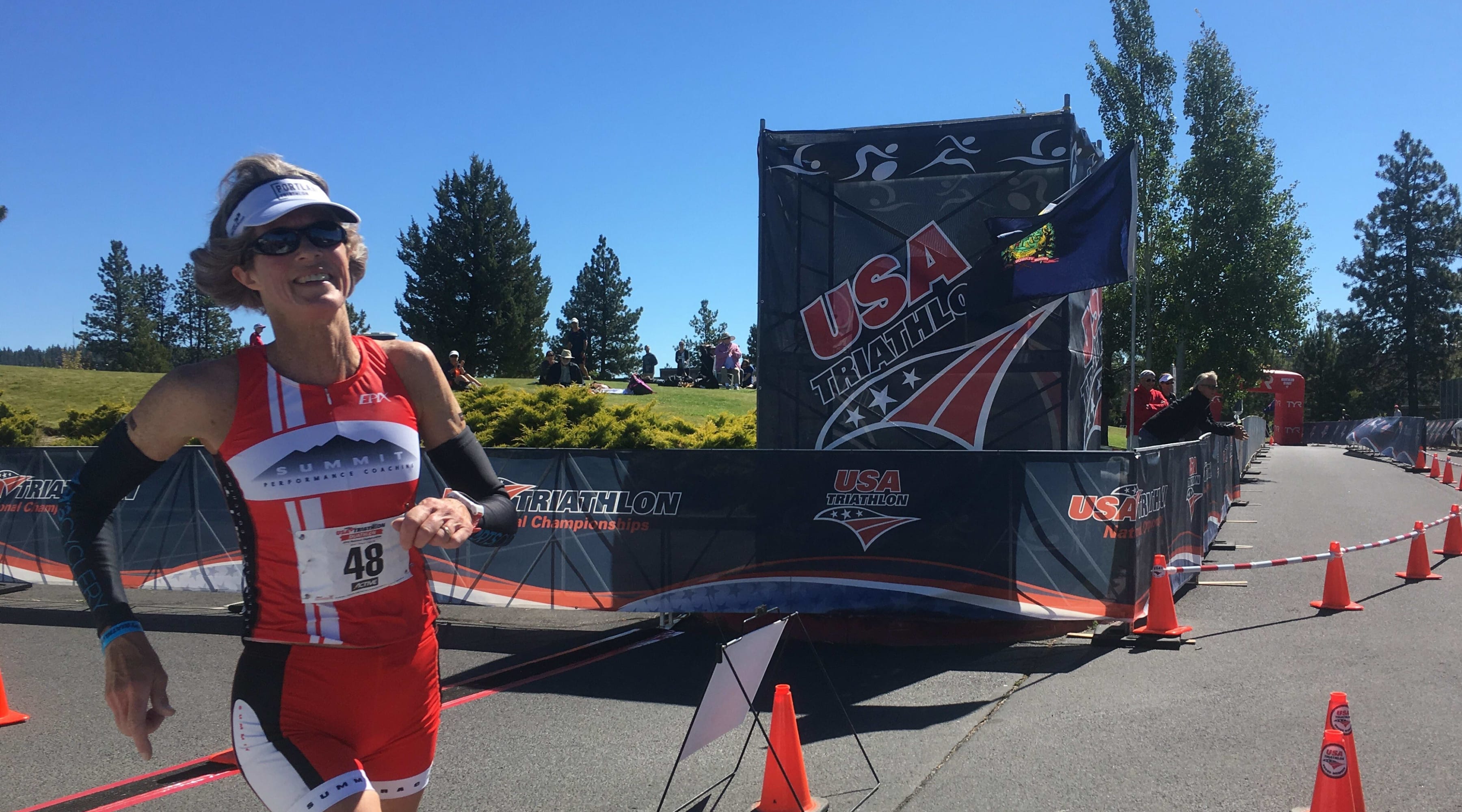 Bridget Dawson runs along a course marked by cones while wearing a race number.