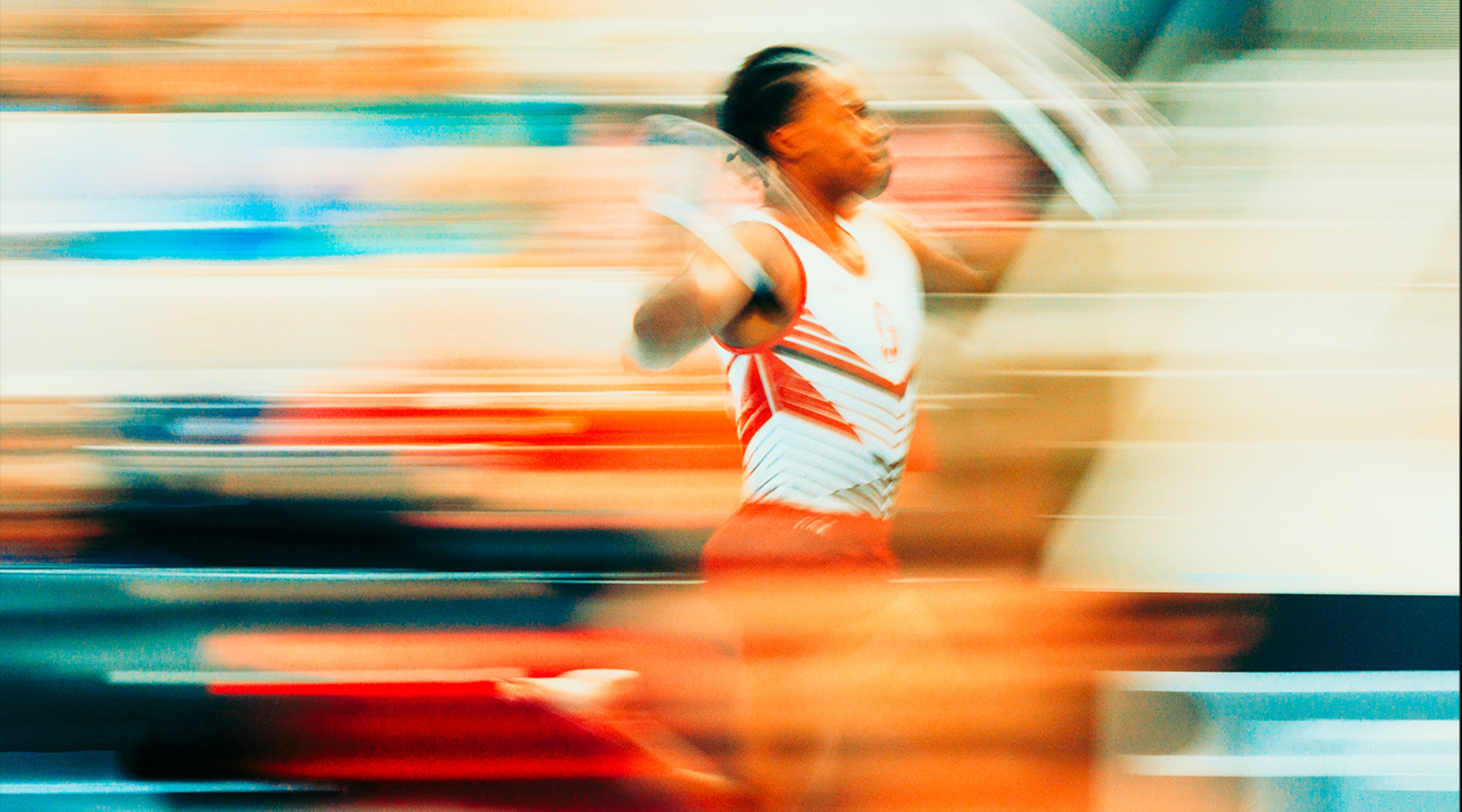 A long exposure photograph of Khoi Young of Stanford Mens Gymnastics running for his vault attempt on night 1 of the US Gymnastics Championship 2023 in San Jose, California.