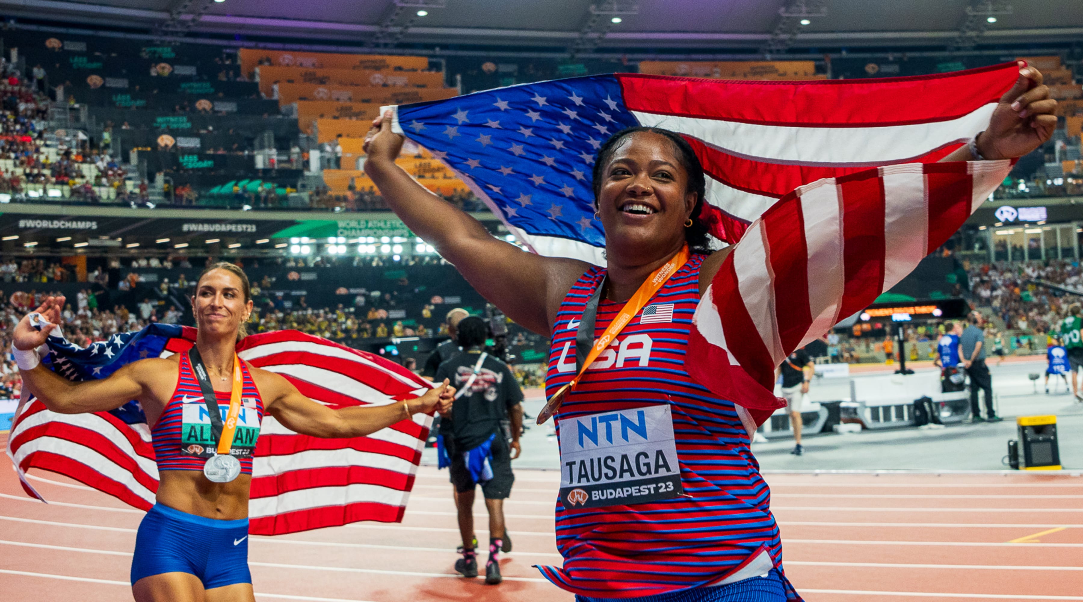 (L-R0 Valarie Allman and Laulauga Tausaga-Collins pose with their U.S. flags.