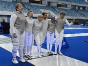 Six women's foil fencers salute their opponents