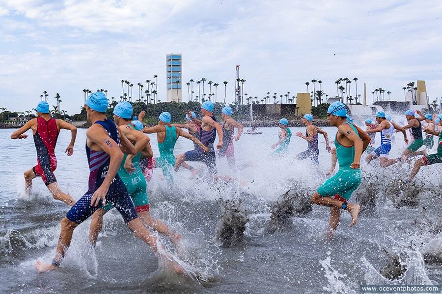 Athletes splash as they run into the water to begin a race at the 2022 Legacy Triathlon.