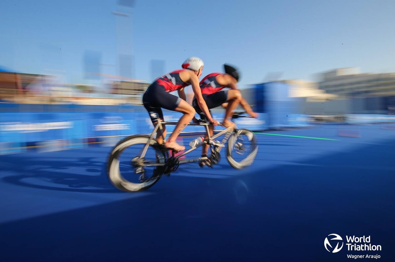 paratriathlete Owen Cravens and his guide Colin Riley race on the tandem bike in a World Triathlon para competition