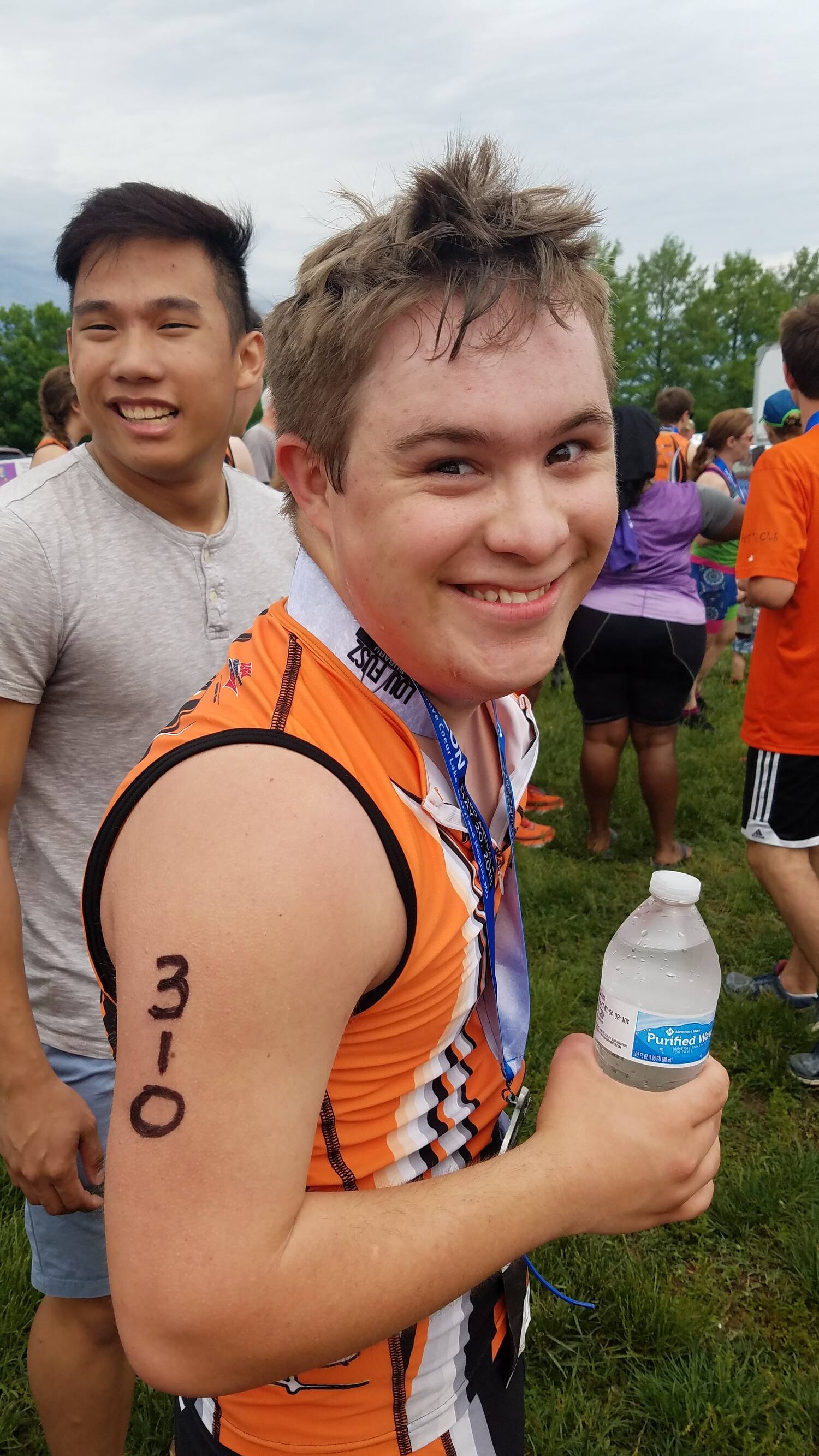 triathlete gabriel cobb smiles while holding his water bottle