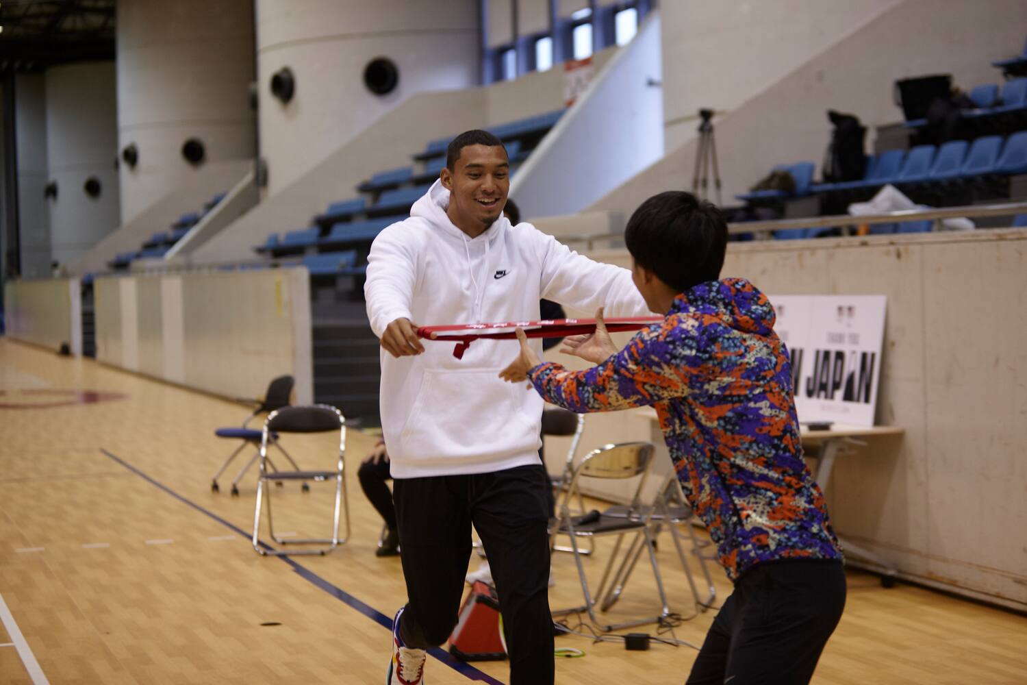 Michael Norman learns how to pass the Tasuki (baton) for the Hakone Ekiden race from a Chuo University student.