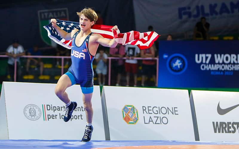 Domenic Munaretto (USA) with the American flag after winning a freestyle gold medal at the 2022 U17 World Championships.