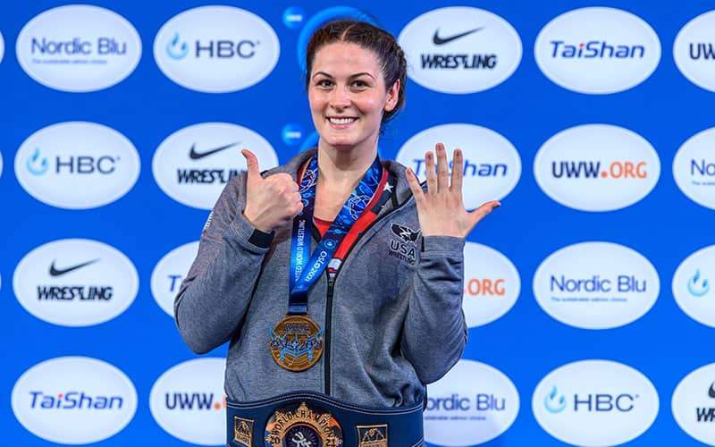 Adeline Gray (USA) on the podium at the 2021 World Championships, with six fingers up for her six World titles