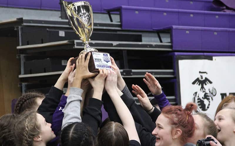 UW-Stevens Point women's wrestling team raises the NCWWC Region 3 team trophy.