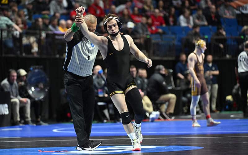 Spencer Lee (Iowa) has arm raised in victory at NCAA Championships.