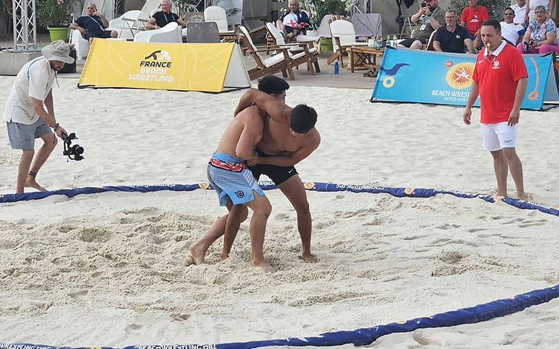 Stanford’s Hunter Garvin (Black) and Daniel Cardenas (Blue) compete in the knockout round of Beach Wrestling World Series in France