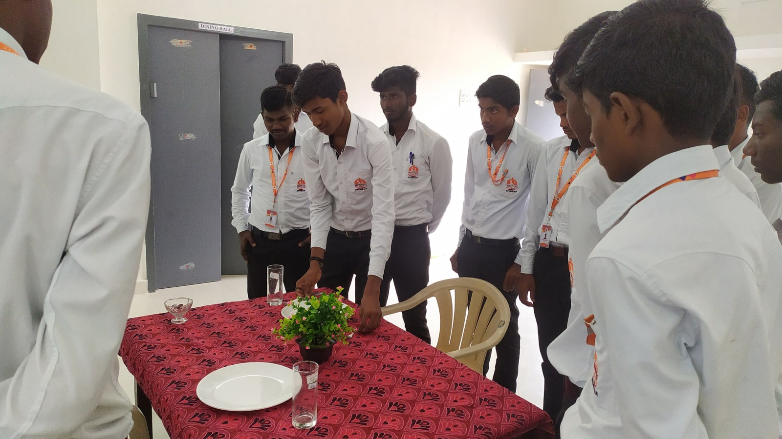 Hospitality trainees practising table setting during a catering and hotel-management course
