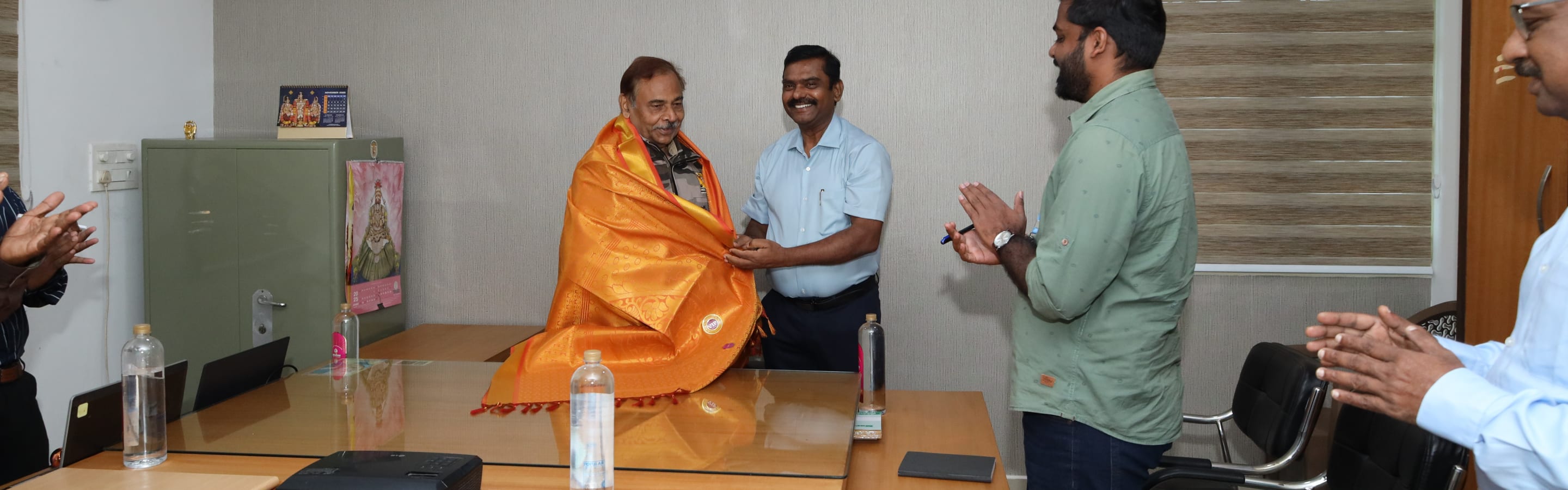 An elder being honoured with a silk shawl at a Coodu Trust ceremony