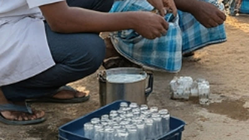 Water samples being collected into glass vials from a steel vessel, with a crate of sample bottles alongside