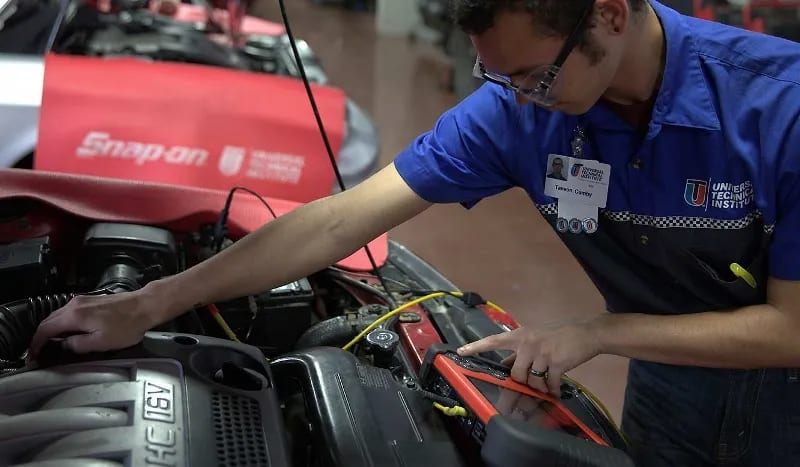 A student checks an automotive oscilloscope in a UTI lab.