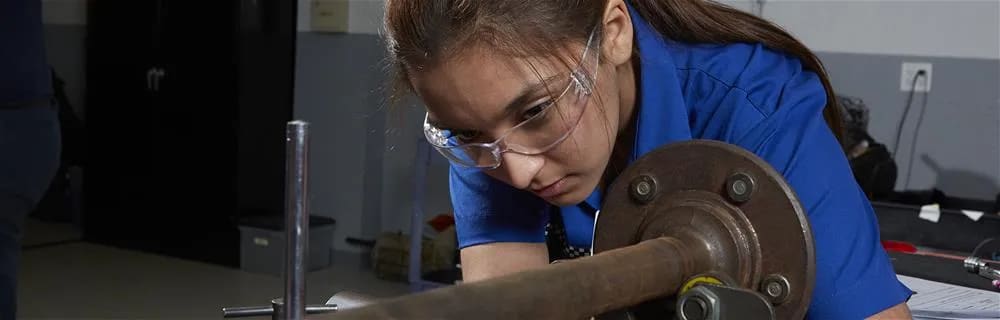 Female student working on car axle.