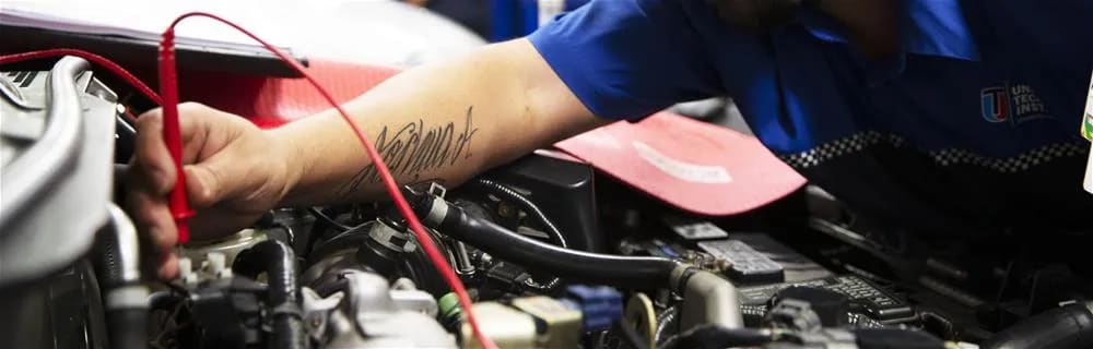 Student checking electrical current running through a vehicle