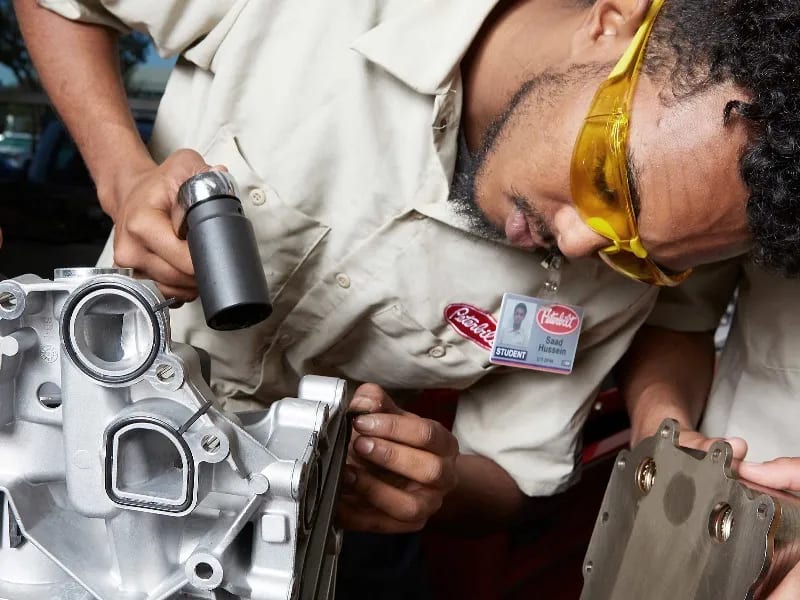 A diesel student works on an engine in a UTI lab.