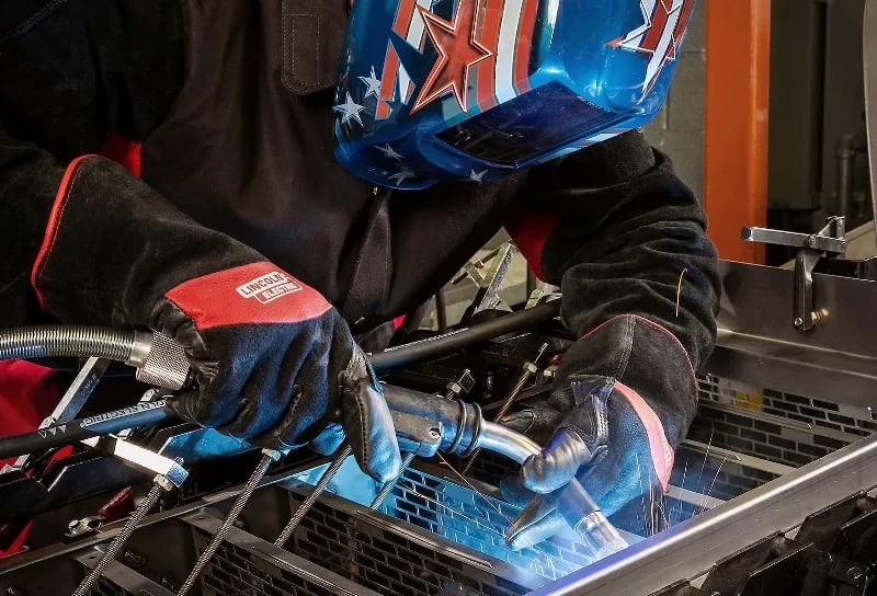 A welder works on a piece of metal.