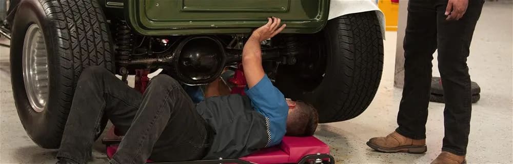 Technician looking under a vehicle