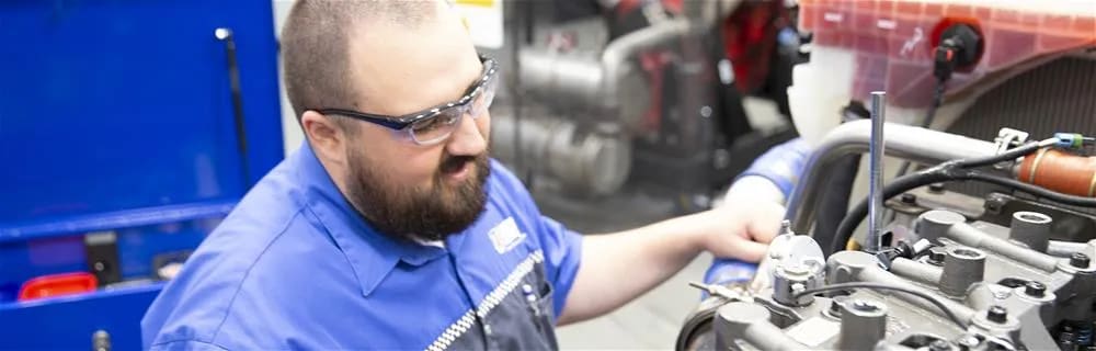 Male student working on a diesel engine block