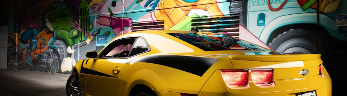 Image of Camaro in front of graffiti wall