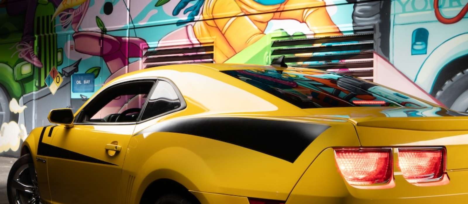 Image of Camaro in front of graffiti wall