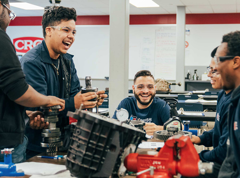 Automotive Technology students share a laugh while training in a lab at UTI Bloomfield.