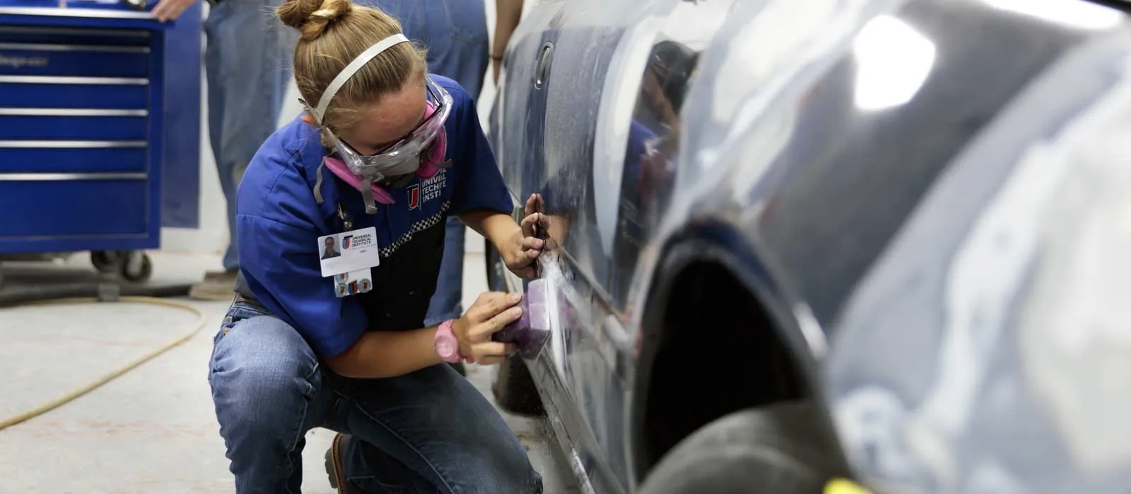 A female CRRT student from UTI who is using essential tools for collision repair technicians