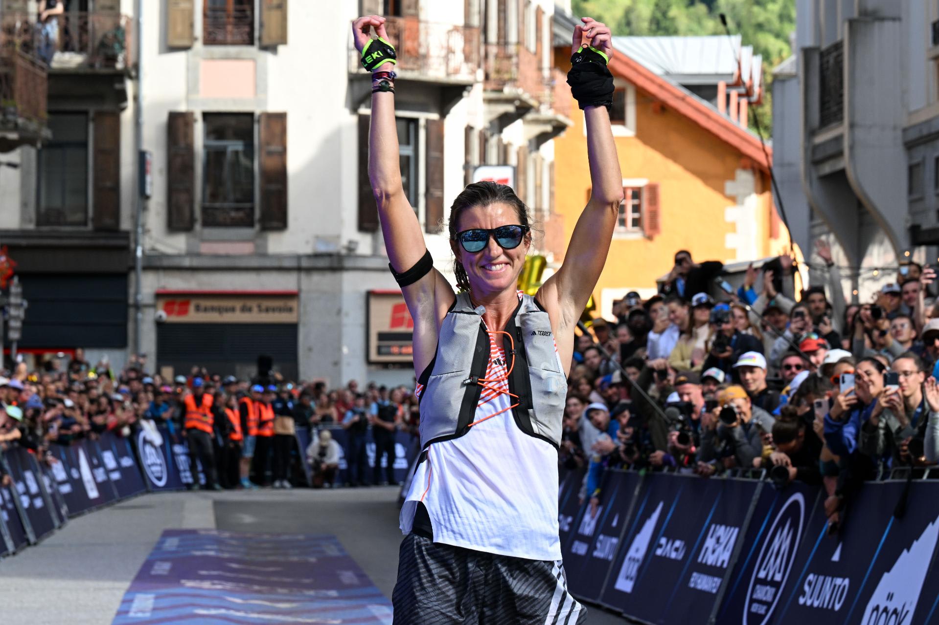tres corredores en la línea de meta de la carrera UTMB Mont Blanc