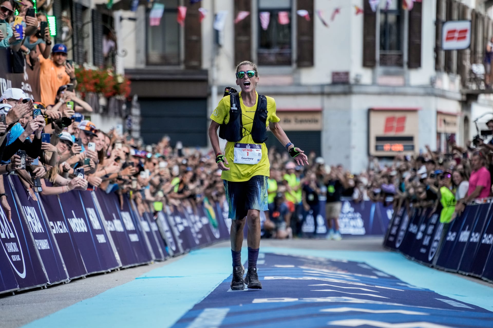 tres corredores en la línea de meta de la carrera UTMB Mont Blanc