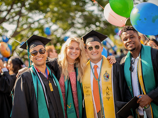 Four Batten graduates standing together