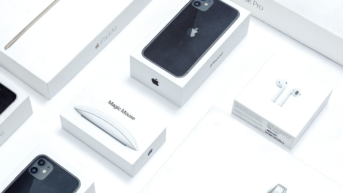 Apple product boxes including iPhone, iPad Air, MacBook Pro and AirPods laid out on a white surface