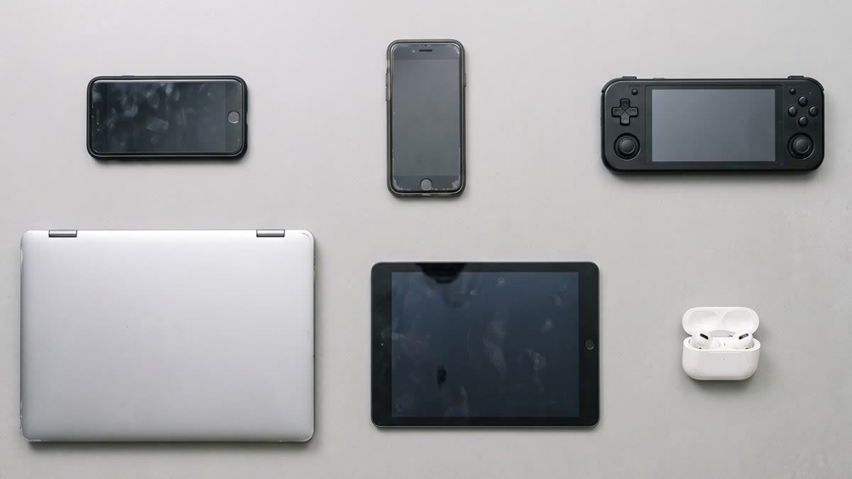 Old phones, a tablet, a games console and a laptop laid out ready to sell for cash