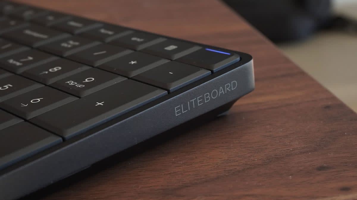 Close-up of the EliteBoard name printed on the front edge of the keyboard, with a blue status light above it
