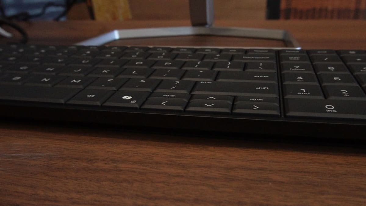 HP EliteBoard G1a on a desk in front of a monitor stand, seen from behind