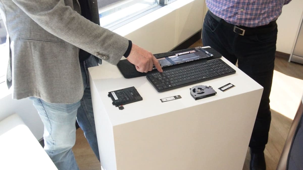 HP representative demonstrating the EliteBoard G1a with its fan, SSD and internal components laid out beside it