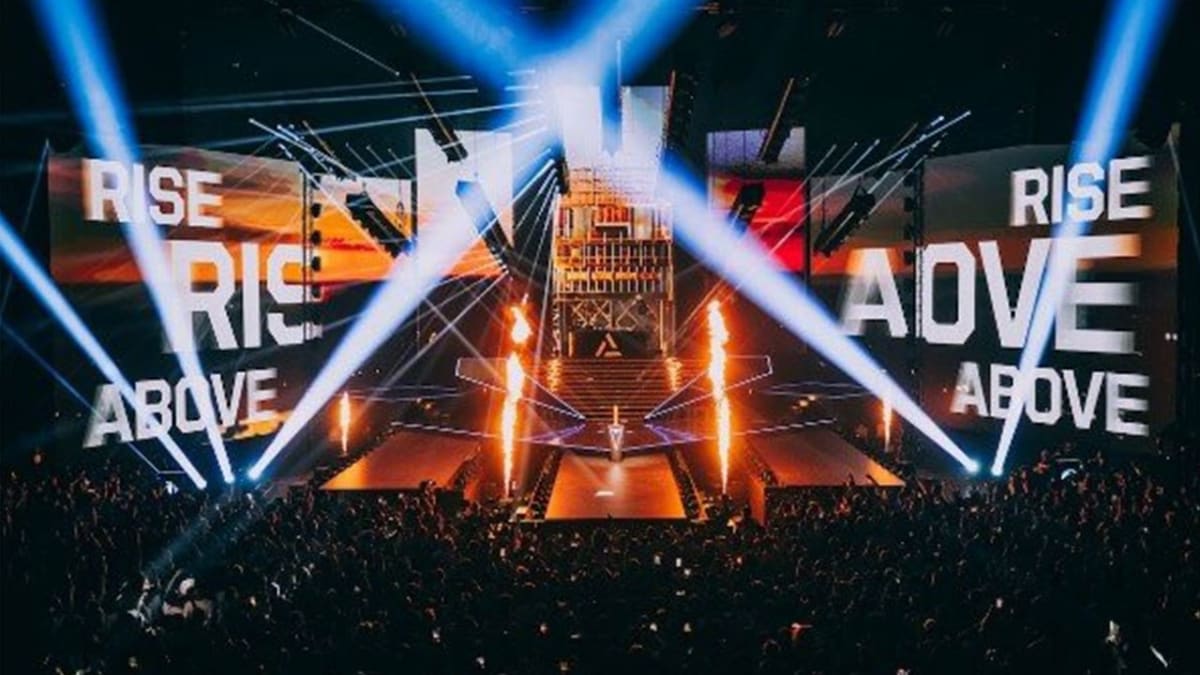 Esports World Cup 2026 main stage in Paris lit by beam lighting, with Rise Above branding on the arena screens above a packed crowd