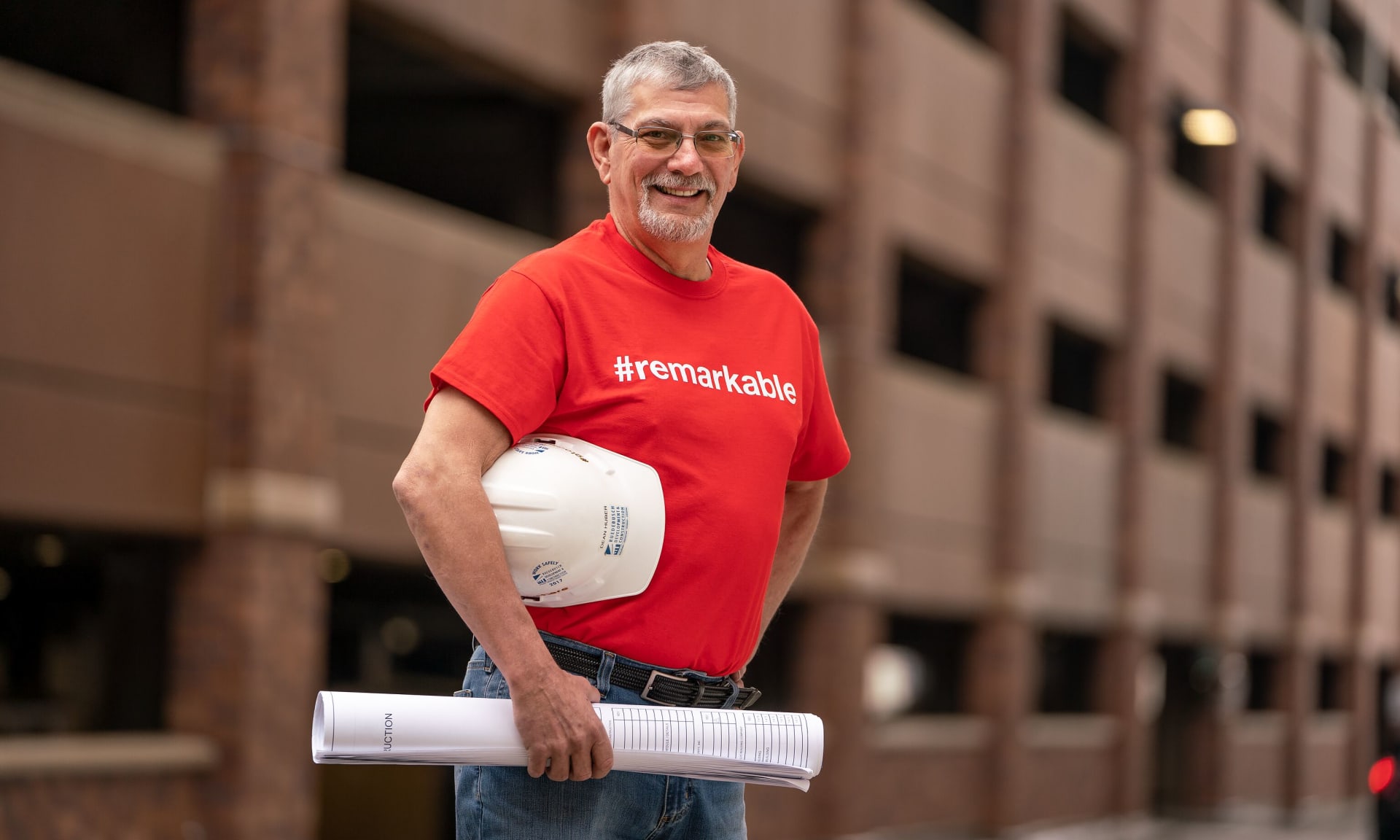 Dean Huber 286539-2649.jpg A man smiling in front of a parking garage