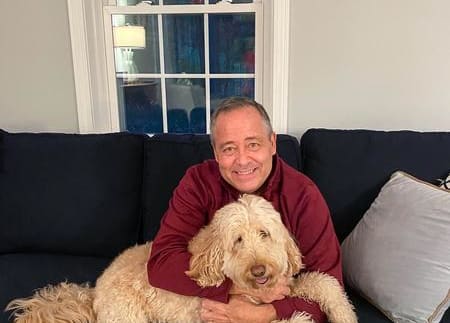 Joe Murray with dog Buddy Joe Murray sitting on the couch with his dog, Buddy.
