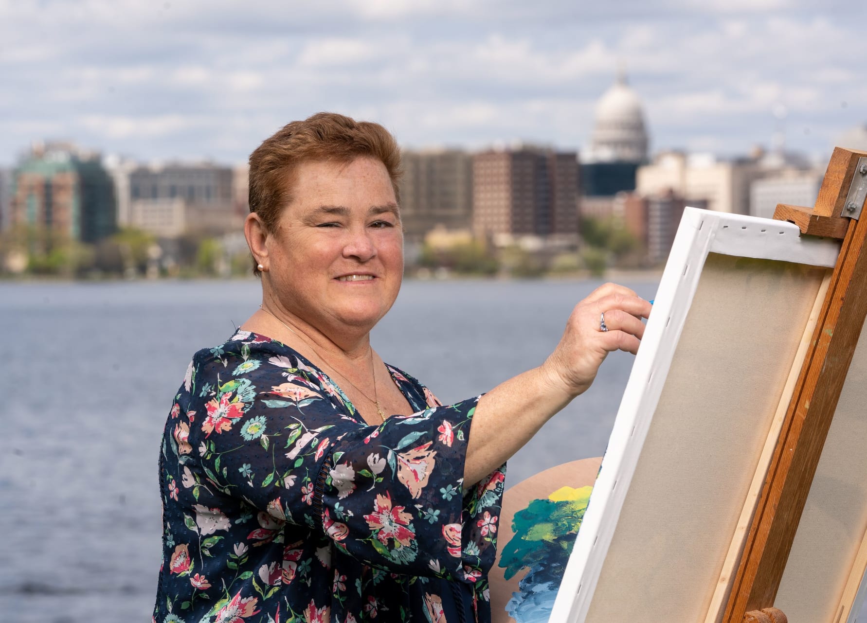 Lorry Adkins 313267-1159 Woman painting on on easel outdoors.