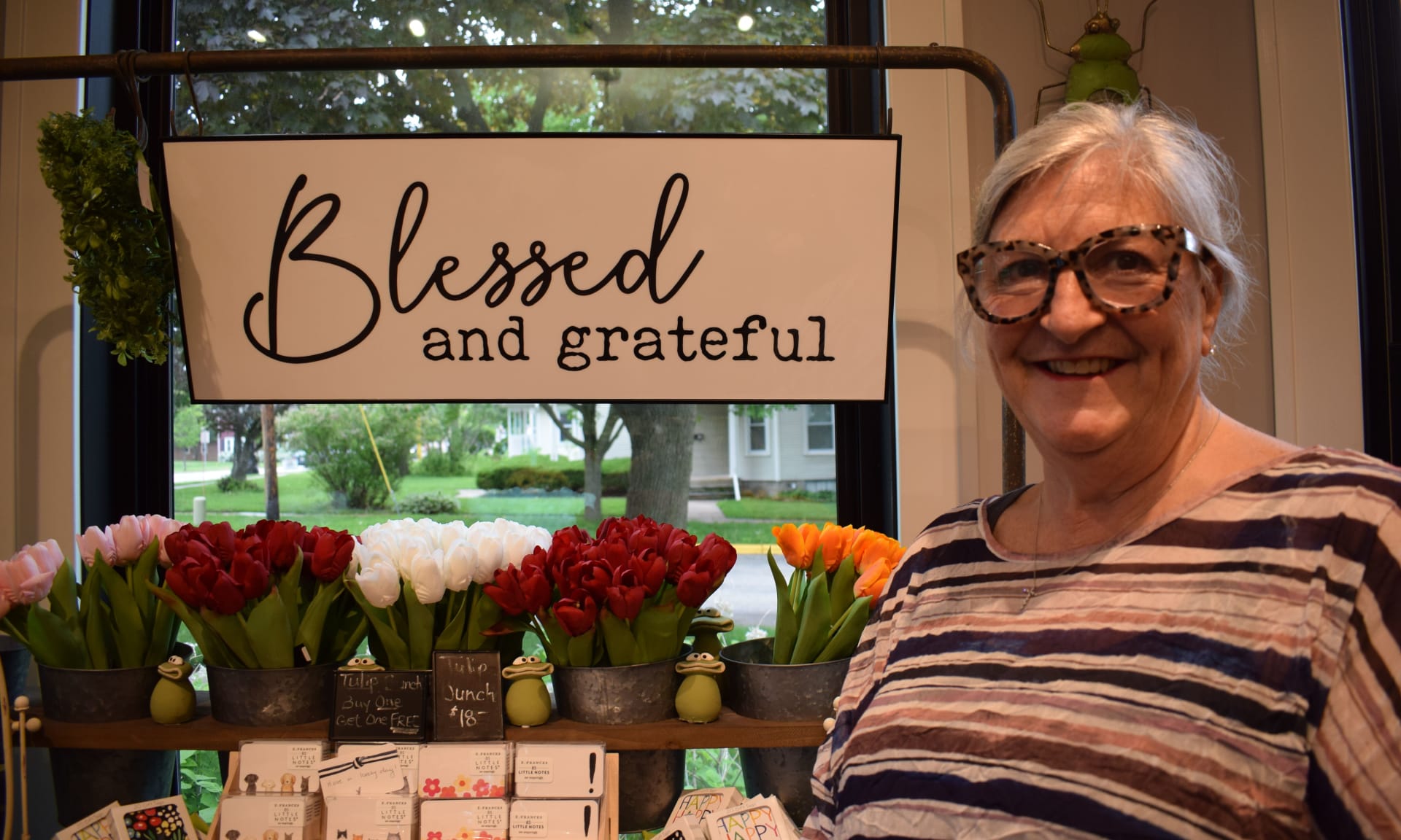 LynnM.jpg Woman smiling next to sign reading Blessed and grateful