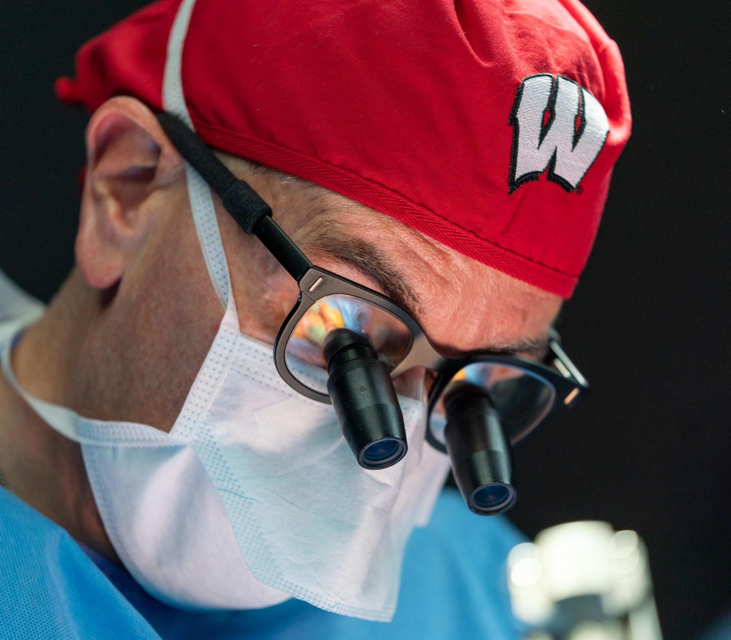 A closeup of a surgeon looking down in an operating room