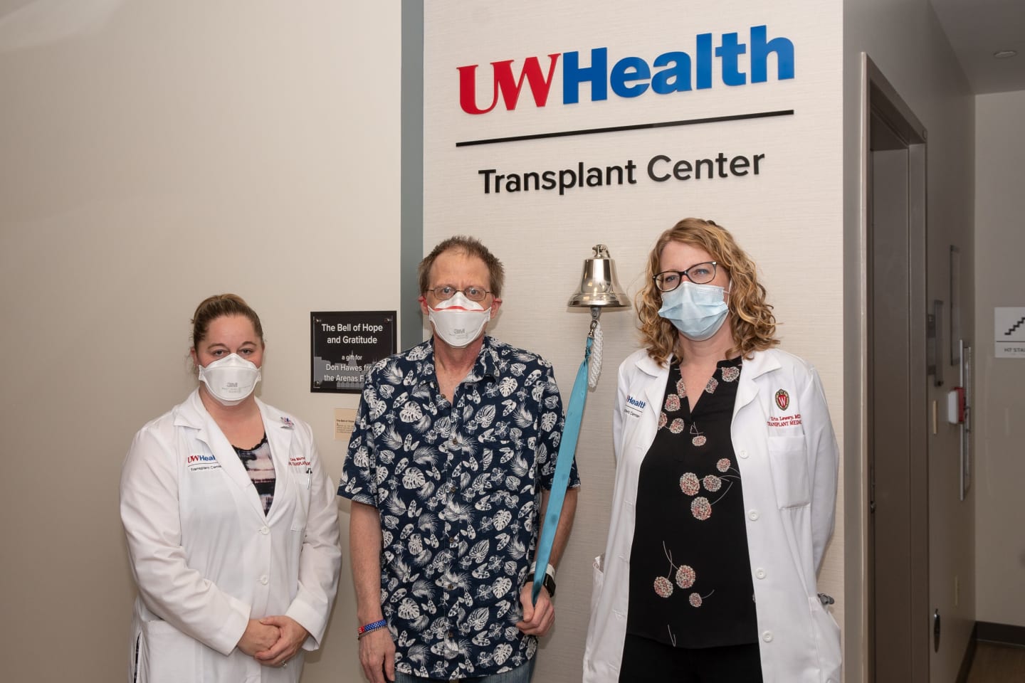 A transplant patient posing for a photo with two of his doctors