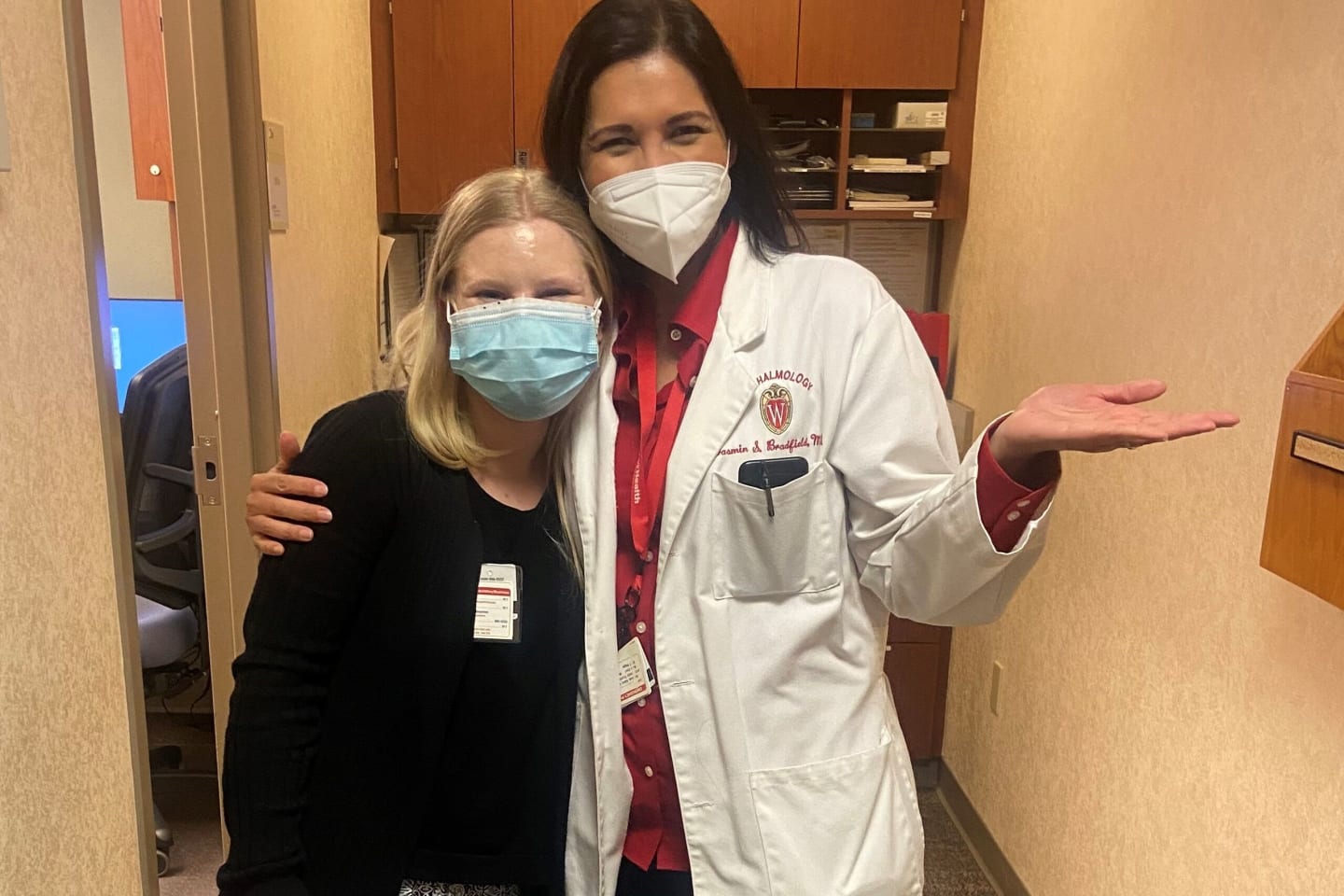 Veronica Blumer and Doctor Yasmin Bradfield standing in a hallway, wearing face masks