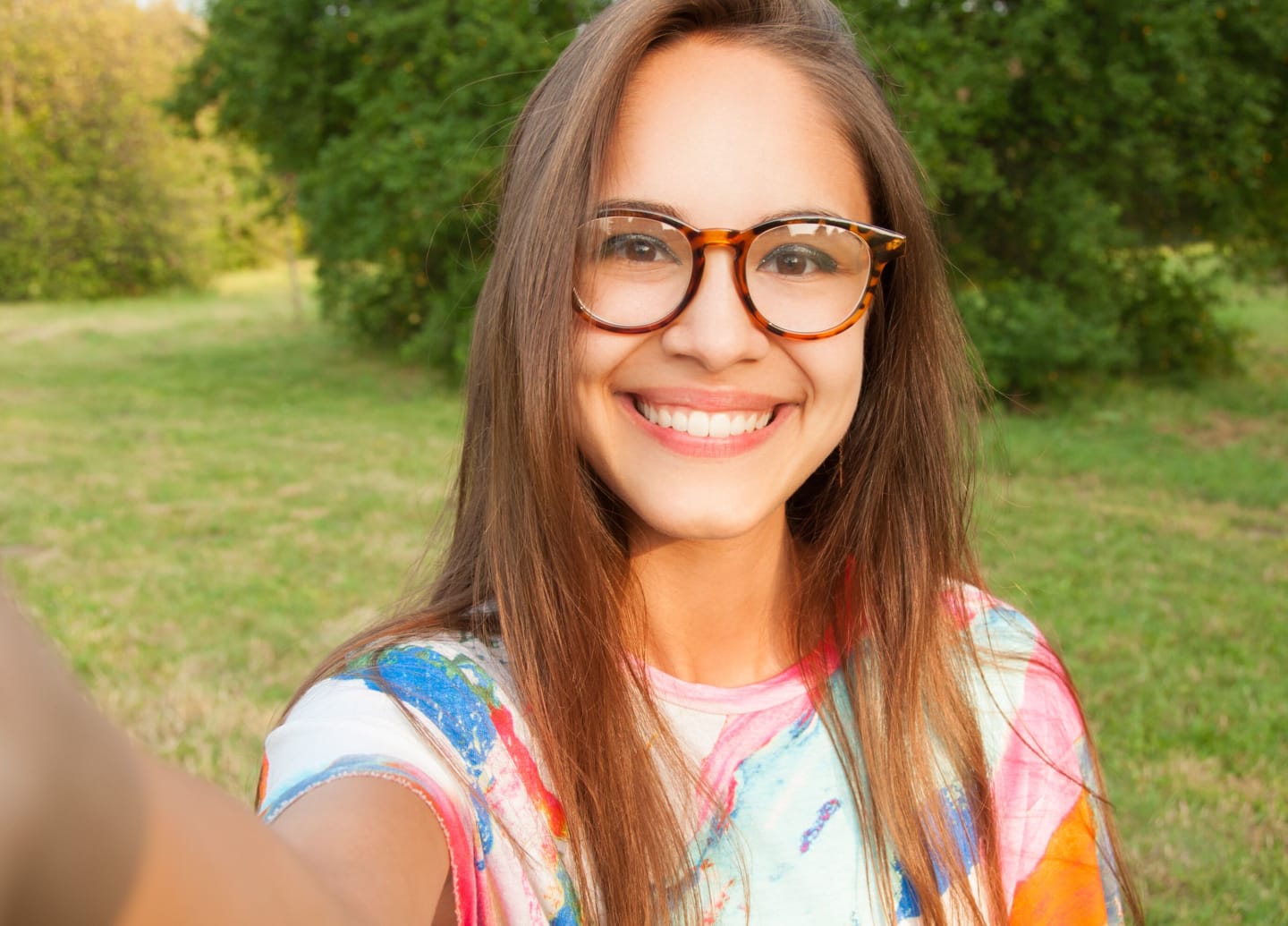 A person smiling, wearing glasses