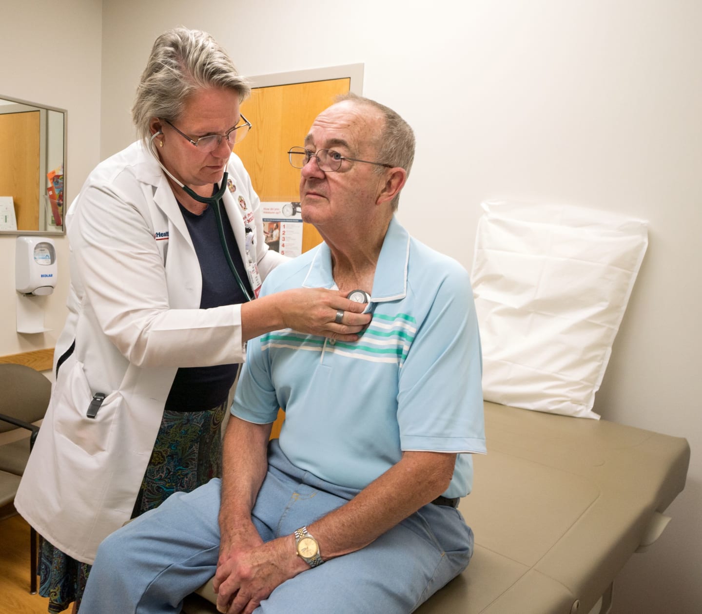 A medical provider using a stethoscope on a patient