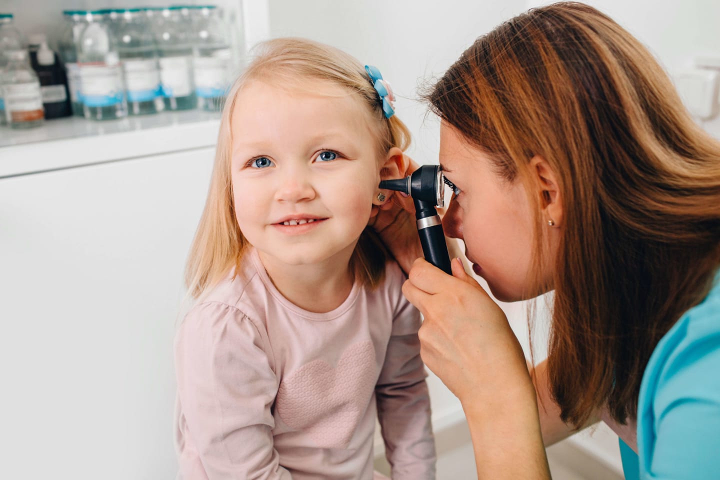 A child having their ear examined by a physician
