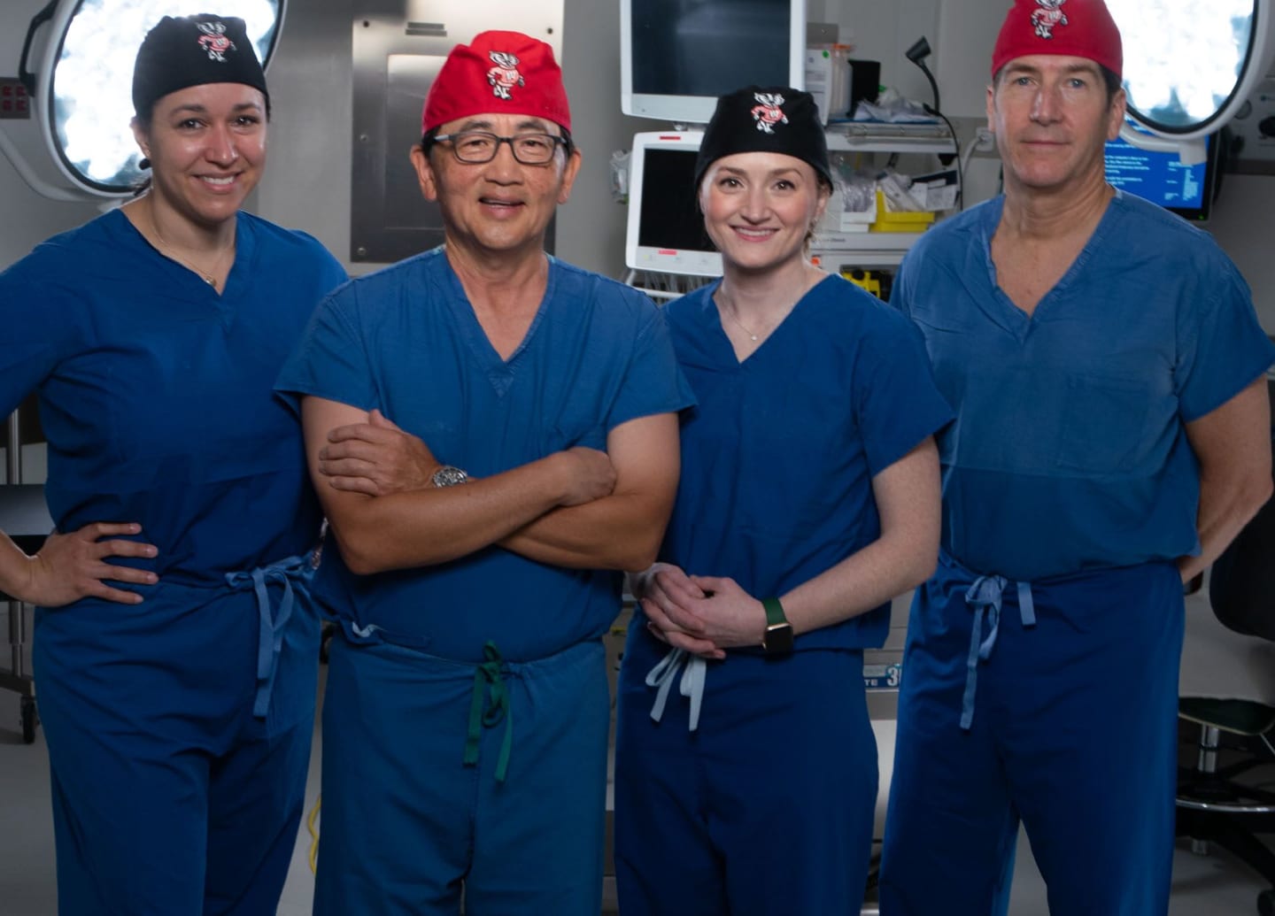 A diverse group of four urological surgeons in an operating room